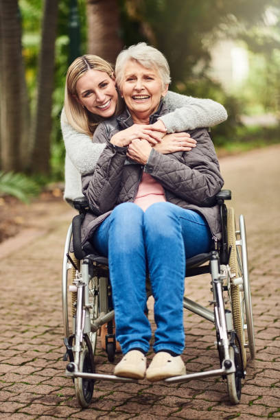 Shot of a senior woman in a wheelchair spending time outdoors with her daughter